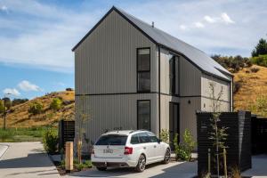 a white car parked in front of a house at Remarkables View, 1BDR, Wi-Fi in Frankton Wharf