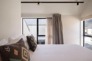 een slaapkamer met een bed en een groot raam bij Remarkables View, 1BDR, Wi-Fi in Frankton
