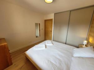 sypialnia z dużym białym łóżkiem z 2 ręcznikami w obiekcie Appartement Les Gets, 2 pièces, 4 personnes - FR-1-598-143 w mieście Les Gets