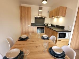 a kitchen with a wooden table with chairs and a dining room at Appartement Les Gets, 2 pièces, 4 personnes - FR-1-598-143 in Les Gets