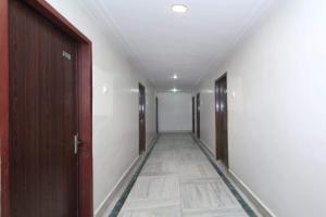 an empty hallway with doors and a tile floor at Capital O Hotel Kartik in Jabalpur