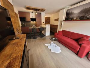 salon z czerwoną kanapą i kuchnią w obiekcie Appartement Les Gets, 2 pièces, 4 personnes - FR-1-598-142 w mieście Les Gets
