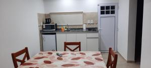 eine kleine Küche mit einem Tisch, einem Tisch und Stühlen in der Unterkunft B&Z Departamentos in Federación