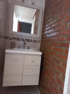 ein Badezimmer mit einem Waschbecken und einer Ziegelwand in der Unterkunft B&Z Departamentos in Federación