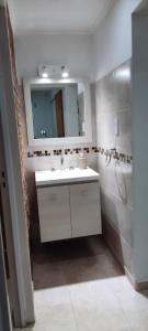 ein Bad mit einem Waschbecken und einem Spiegel in der Unterkunft B&Z Departamentos in Federación