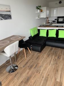 uma sala de estar com um sofá preto e uma mesa em Apartament SKYSCRAPPER z widokiem na panoramę Warszawy em Varsóvia