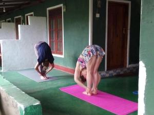 Dos chicas están haciendo yoga en una habitación en Bandula Home Stay en Sigiriya