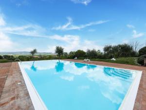 a swimming pool with blue water in a villa at Belvilla by OYO Appartamento Panorama in Asciano
