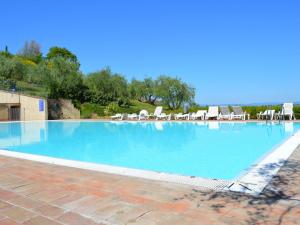 duży basen z krzesłami i niebieską wodą w obiekcie Holiday Apartment Close to Asciano w mieście Asciano