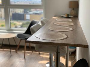 een houten tafel met vier stoelen eromheen bij Apartament SKYSCRAPPER z widokiem na panoramę Warszawy in Warschau