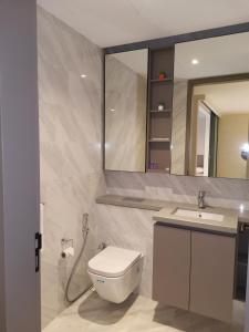 a bathroom with a toilet and a sink and a mirror at EATON RESIDENCE AT KLCC in Kuala Lumpur