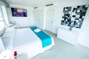 una camera bianca con letto e TV di Suite 1107 Hermosa vista al rió Guayas con Jacuzzi a Guayaquil