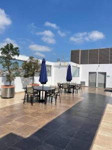 un patio con tavoli, sedie e ombrelloni blu di Suite 1107 Hermosa vista al rió Guayas con Jacuzzi a Guayaquil