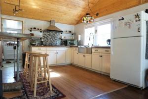a kitchen with a white refrigerator and wooden ceilings at Cozy Home with Big Yard - Full Kitchen-More Than a Hotel Stay! in Lyles
