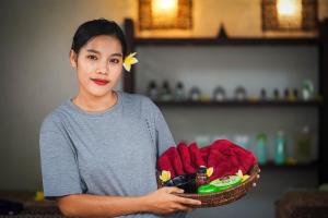 a woman holding a basket of food and drinks at Marygio Gili Resort in Gili Trawangan