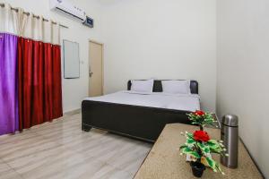 a bedroom with a bed and a red curtain at SPOT ON Hotel All Orchha View in Orchha