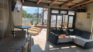 a living room with a couch and a table on a patio at 8 Quarto Cama Queen e SmartTv Netflix in Itajaí