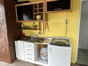 uma pequena cozinha com um lavatório e uma máquina de lavar roupa em 8 Quarto Cama Queen e SmartTv Netflix em Itajaí