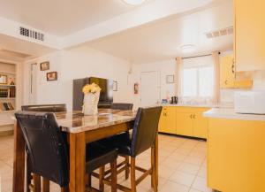 eine Küche mit einem Tisch mit Stühlen und einem Kühlschrank in der Unterkunft 1 or 3 Bedroom Apartment with Full Kitchen in Page
