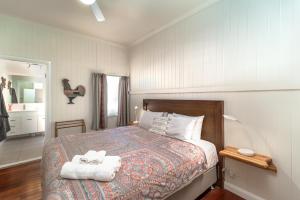 a bedroom with a bed with two towels on it at Bank House Tamborine Mountain in Mount Tamborine