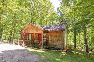 ein winziges Haus mit einer roten Tür im Wald in der Unterkunft Pet friendly Luxury Cabin near Helen with fire pit in Cleveland