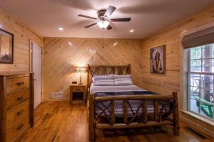 1 dormitorio con 1 cama y ventilador de techo en Pet friendly Luxury Cabin near Helen with fire pit en Cleveland