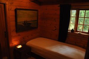 a bedroom with a bed and a picture on the wall at Bjælkehuset på Harrild Hede in Brande