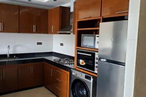 a kitchen with a refrigerator and a washer and dryer at New apartment with water view in El Jadida