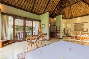 um quarto com uma mesa e cadeiras num quarto em Suara Air Luxury Villa Ubud em Ubud