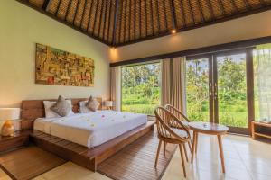 um quarto com uma cama, uma mesa e cadeiras em Suara Air Luxury Villa Ubud em Ubud