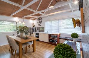 uma cozinha com uma mesa e uma sala de jantar em The Chefs Cottage em Waikanae