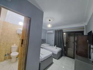 La petite salle de bains est pourvue de toilettes et d'un lavabo. dans l'établissement NADA _ HOTEL, au Caire