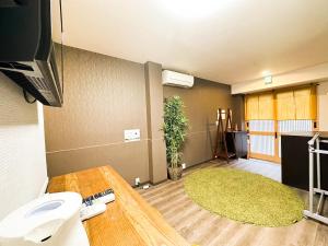 a room with a bathroom with a sink and a tv at Funhouse-to-101 North Umeda 12ppl Condo in Osaka