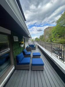 a deck with blue cushioned chairs on a balcony at Sleek 1 Bedroom Apartment Plus Balcony 30 Mins to NYC in New Rochelle