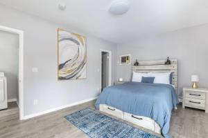 a white bedroom with a blue bed and a blue rug at Near NYC Luxury modern 1bed apt plus Sofa Bed & Balcony in New Rochelle