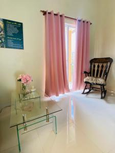 een woonkamer met een stoel en een glazen tafel bij Oasis de Paz 2.1 in Jarabacoa