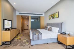 a bedroom with a bed and a flat screen tv at United Kingson HoteL in Chengdu