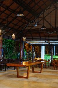 a large wooden table in a restaurant with tables and chairs at Doi Inthanon View Resort in Chom Thong