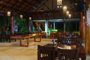 Doi Inthanon View Resort في تشوم تونغ: مطعم بطاولات وكراسي خشبية في الغرفة