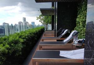 Sathon Luxury High-rise Apartment City View KingPower ,IconSiam ,BNH,Silom في بانكوك: صف من المقاعد على سقف مبنى