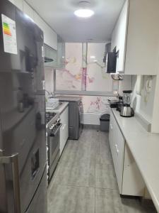 eine Küche mit weißen Schränken und einem großen Fenster in der Unterkunft Departamento familiar in Lima