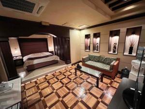 una camera con un letto e un divano di HOTEL ULURU a Kobe