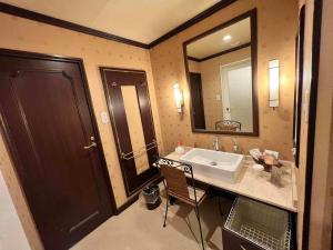 un bagno con un lavandino e un grande specchio di HOTEL ULURU a Kobe