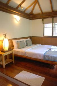 ein Schlafzimmer mit einem Bett und einer Lampe auf einem Tisch in der Unterkunft Montalay Beach Resort in Ko Tao