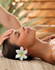 a woman laying on a bed with a flower on her face at Opoa Beach Hotel in Opoa