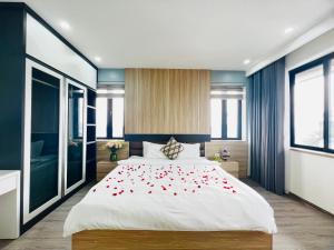 ein Schlafzimmer mit einem Bett mit roten Rosen darauf in der Unterkunft Trippy villa: FLC Hạ Long in Hạ Long