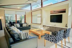 a living room with a couch and a table at Beach Haven in Point Lonsdale