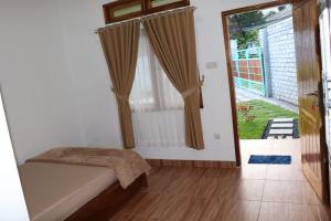 a bedroom with a bed and a door to a yard at Room 212 in Kuta Lombok