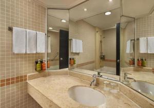 a bathroom with two sinks and a large mirror at Holiday Inn Singapore Atrium, an IHG Hotel in Singapore