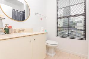 a white bathroom with a toilet and a mirror at Home Miami Downtown - 5 minutes from Wynwood & Port - Art District near Beach in Miami